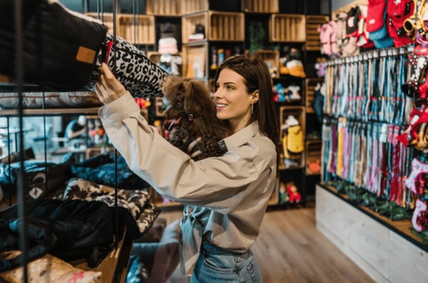 A customer in a pet store looking at a wall of well-known brand-name